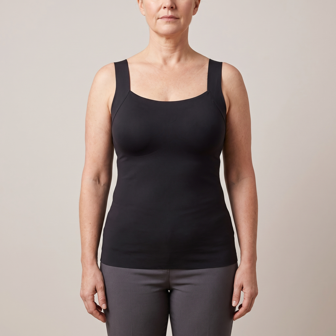 Woman wearing a black vest top with built-in bra cups – non-wired bra vest, no underband